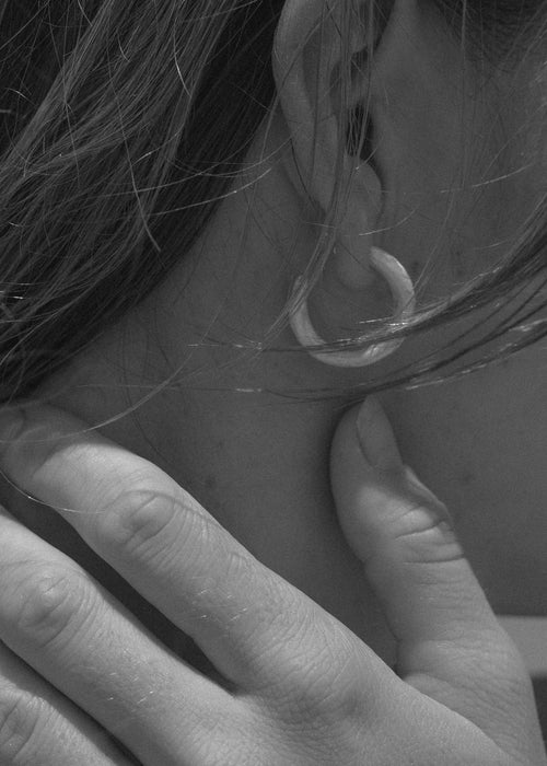 Frau trägt handgefertigten Ohrring
